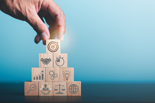 Male hands stacking wooden blocks,Business targeting and focus concept,the growth and purpose of the organization,Competitive marketing strategy planning management,Optimize team success